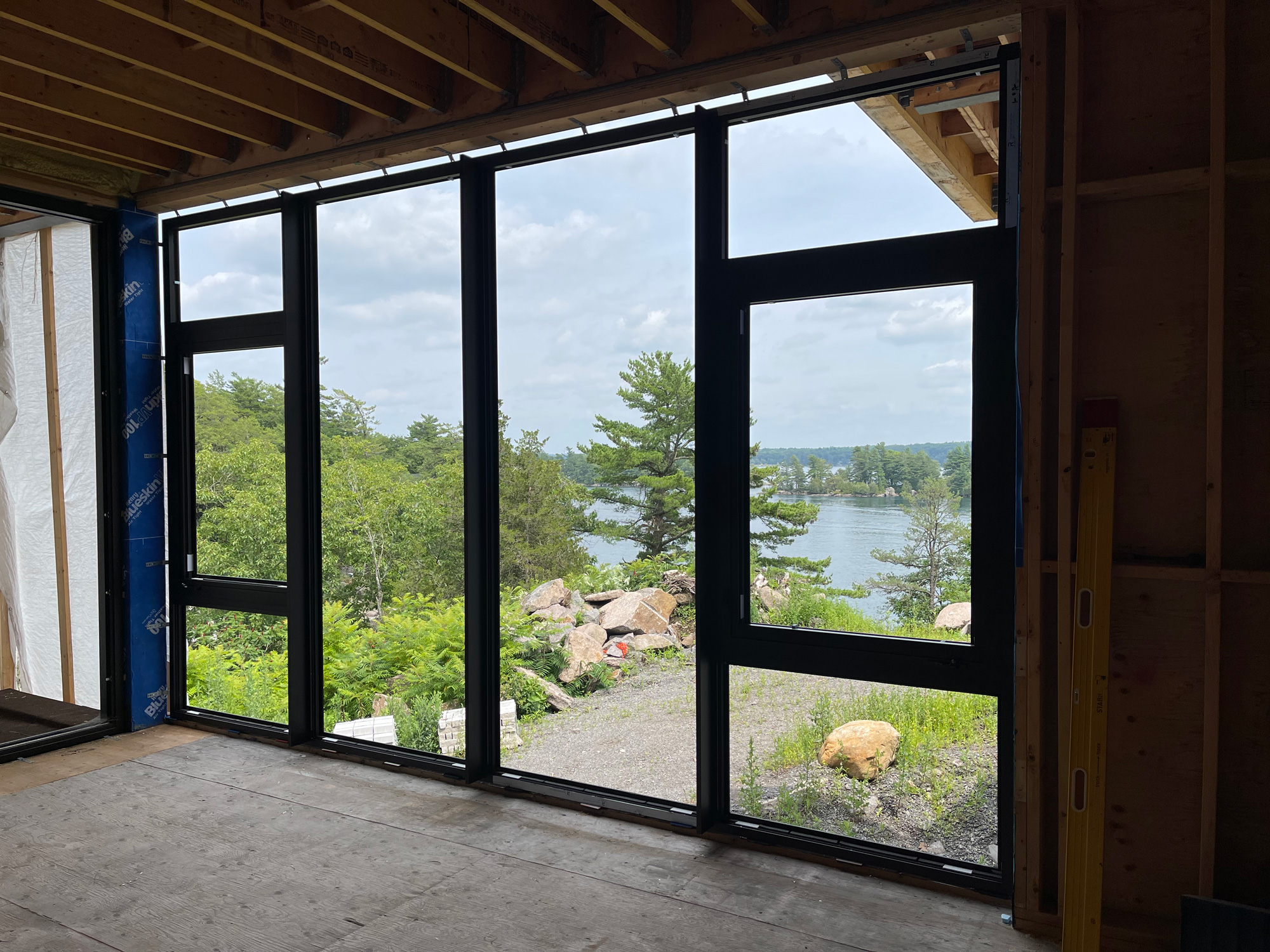 Interior view of a Georgian Bay cottage with Reynaers Aluminum MasterLine 8 European windows, combining fixed glazing and operable units overlooking the bay.