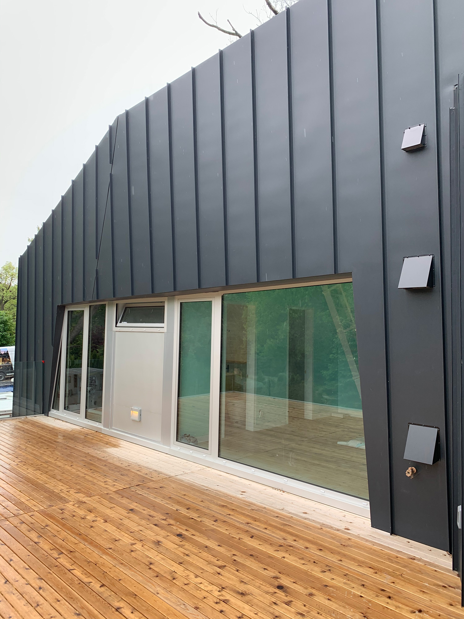 Combination of fixed Reynaers CS77 glazing, tilt-and-turn windows, and panel insert in natural anodized finish on a modern Sarnia home.