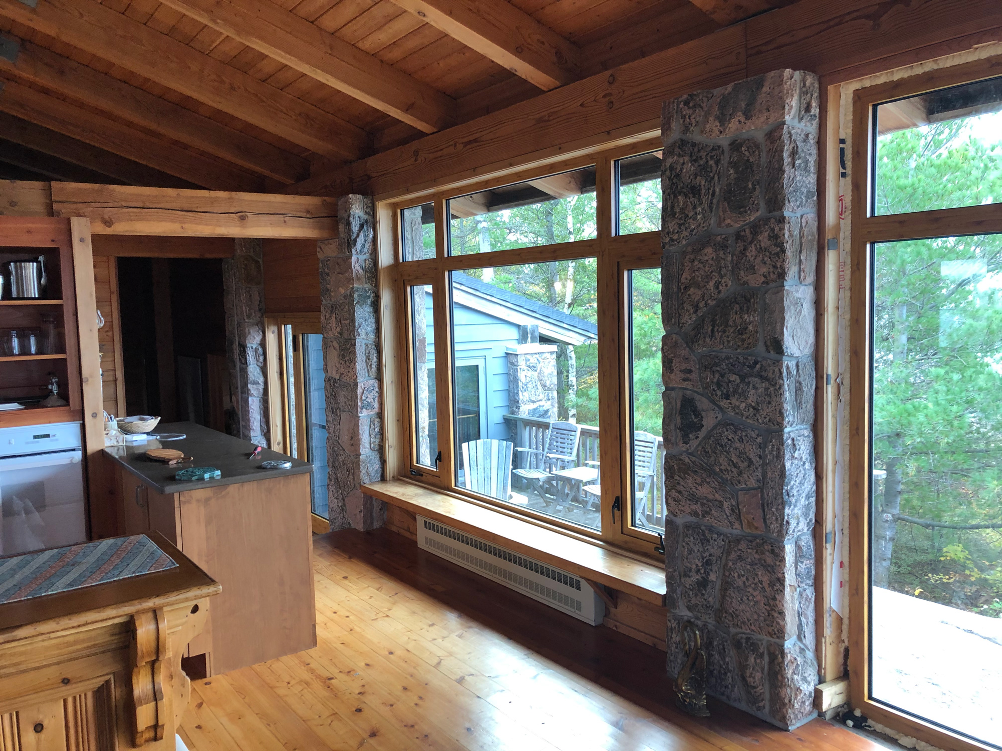 Interior view of Reynaers CS77 windows combining fixed glazing with roto-casement operators in a wood-finished Georgian Bay island cottage.