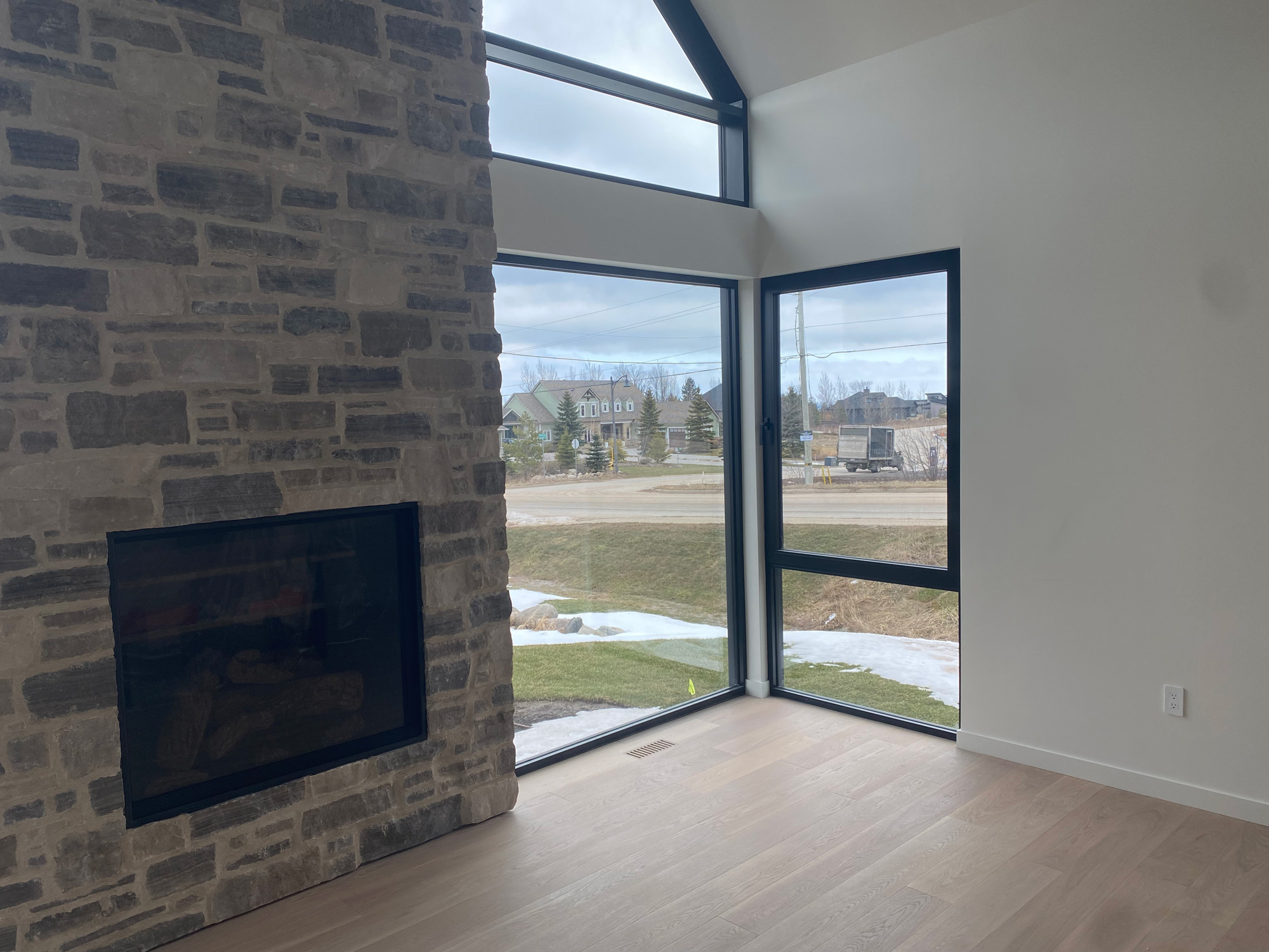 Installed Reynaers SL38 tilt-turn window paired with fixed glazing in modern great room, emphasizing minimalist slim-line aluminum frames.