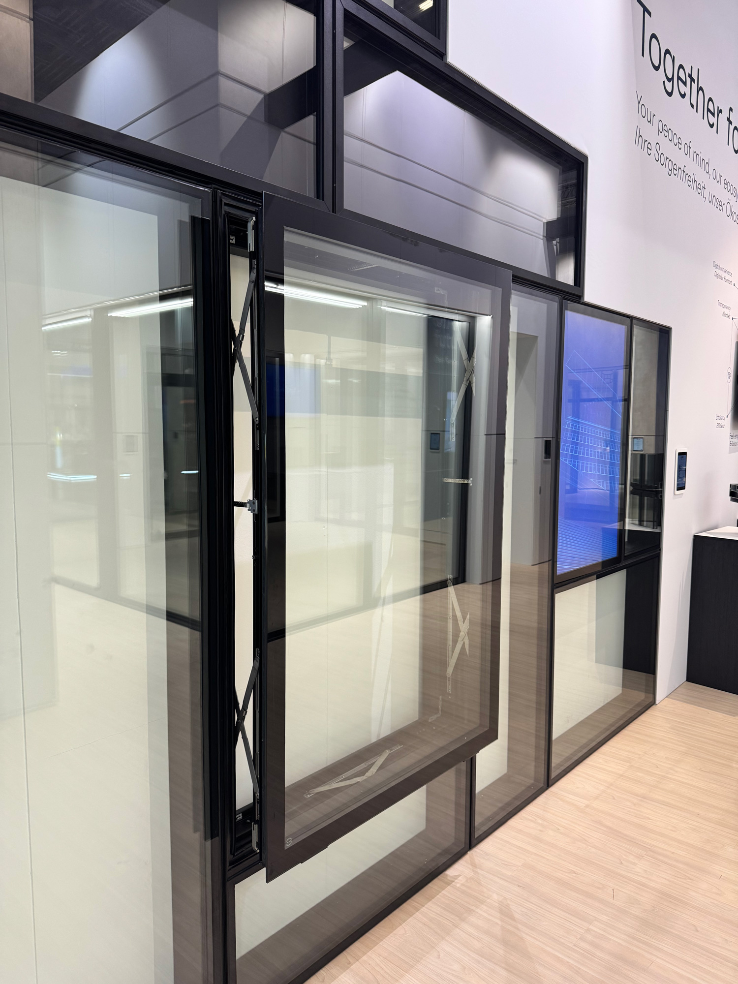 Show display at BAU featuring a Reynaers Aluminum parallel opening window system, highlighting innovative European design and ventilation performance.