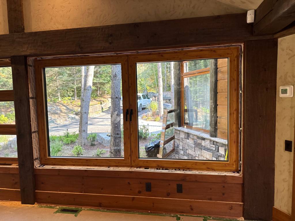 Interior view of a Mont Tremblant cottage after wood sublimation applied to Reynaers Aluminum windows, seamlessly matching the rustic timber design.