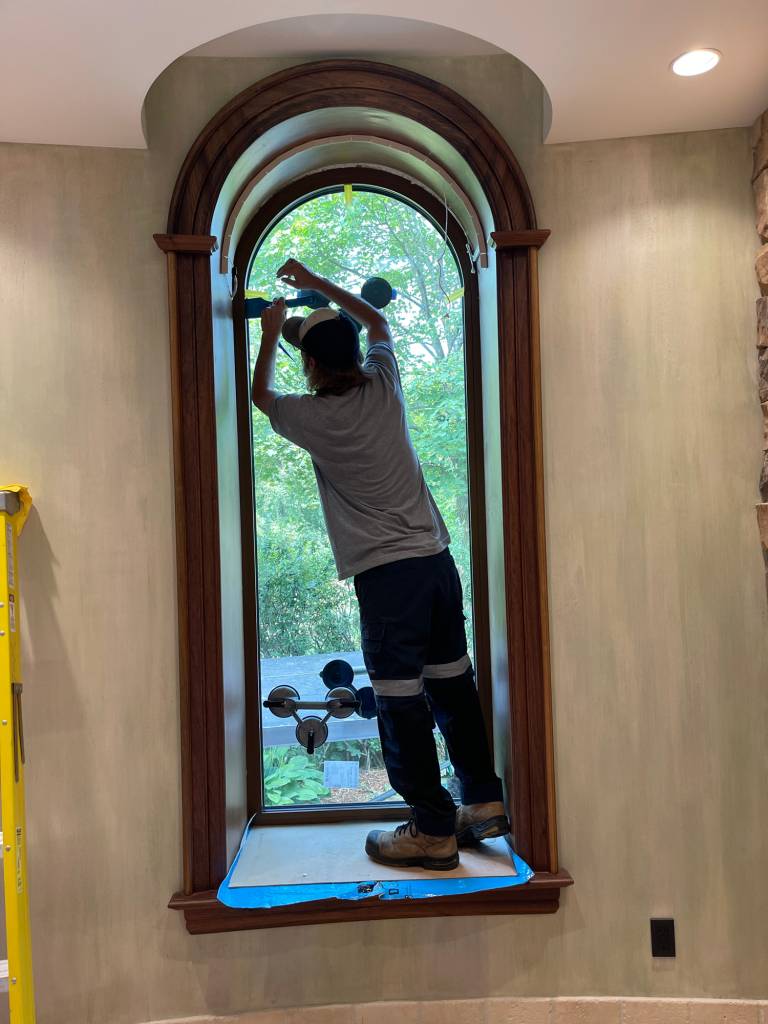 Installation of a Reynaers Aluminum MasterLine 8 arched window retrofit at a King City home, blending modern performance glazing into a traditional wood surround.