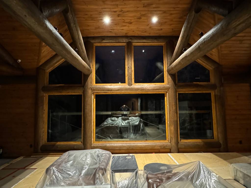 Great room wall of a cottage featuring Reynaers Aluminum MasterLine 8 fixed windows, including two raked units, finished with wood sublimation for a natural timber look.