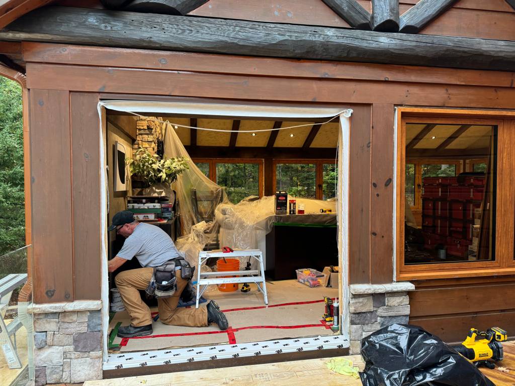 Installation in progress at a cottage showing Reynaers Aluminum MasterLine 8 window already fitted, with opening prepared for a matching French door system.