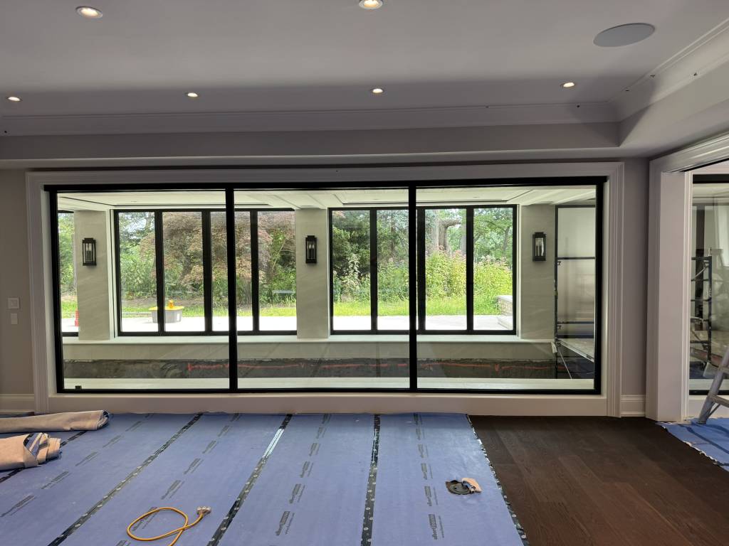 Interior view of a Toronto modern home with Reynaers Aluminum MasterLine 8 window wall dividing the swimming pool area from the living space, combining performance and design.