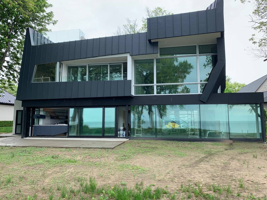 Angled black modern house in Sarnia featuring Reynaers CS77 windows and doors in natural anodized finish.