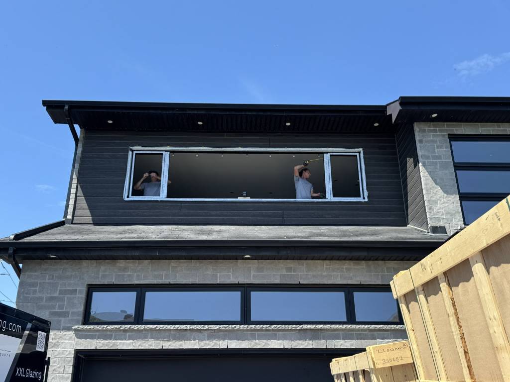Retrofit installation at a Toronto home featuring Reynaers Aluminum MasterLine 8 windows with two tilt-turn operators set between a large fixed unit, providing modern performance glazing.
