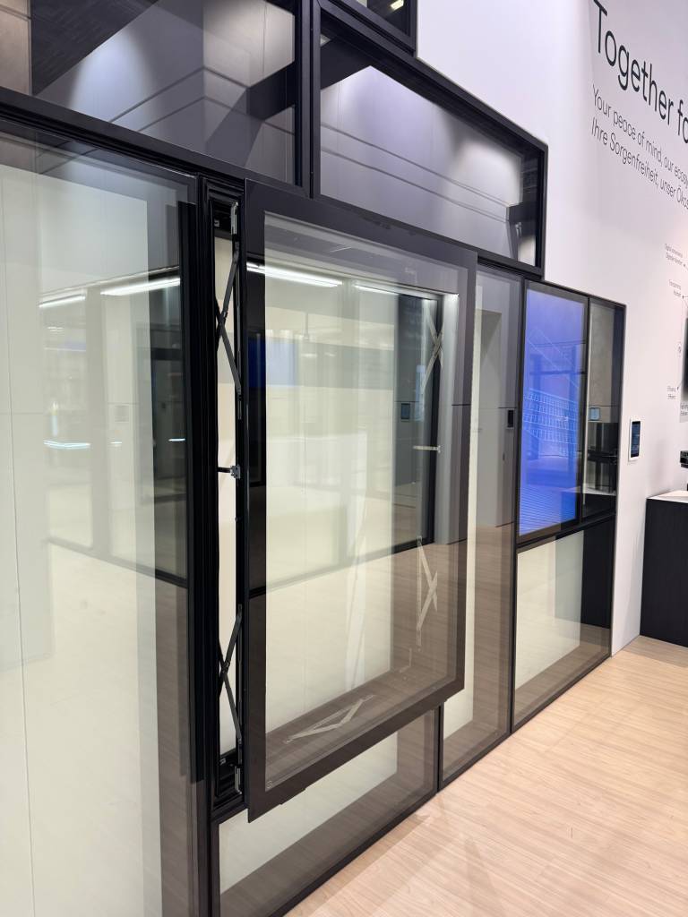 Show display at BAU featuring a Reynaers Aluminum parallel opening window system, highlighting innovative European design and ventilation performance.