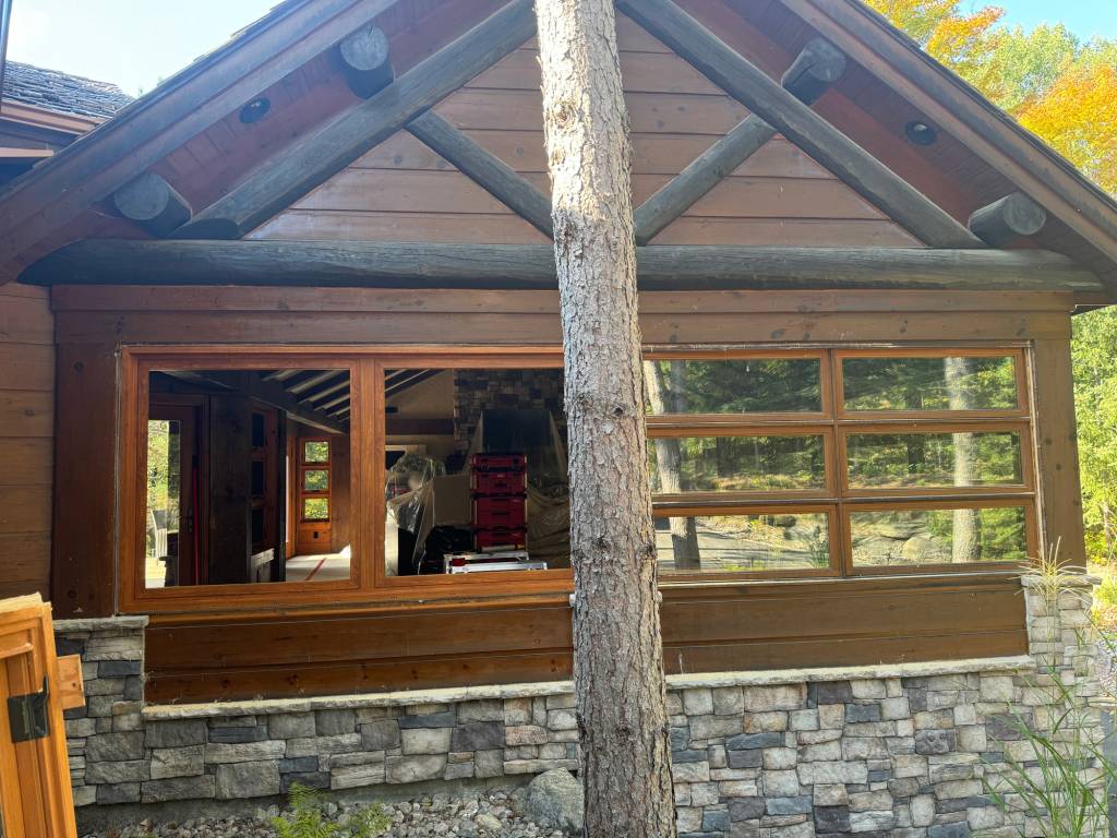 Before and after view of a Mont Tremblant cottage project featuring wood sublimation on Reynaers Aluminum windows, blending modern performance with a natural timber look.