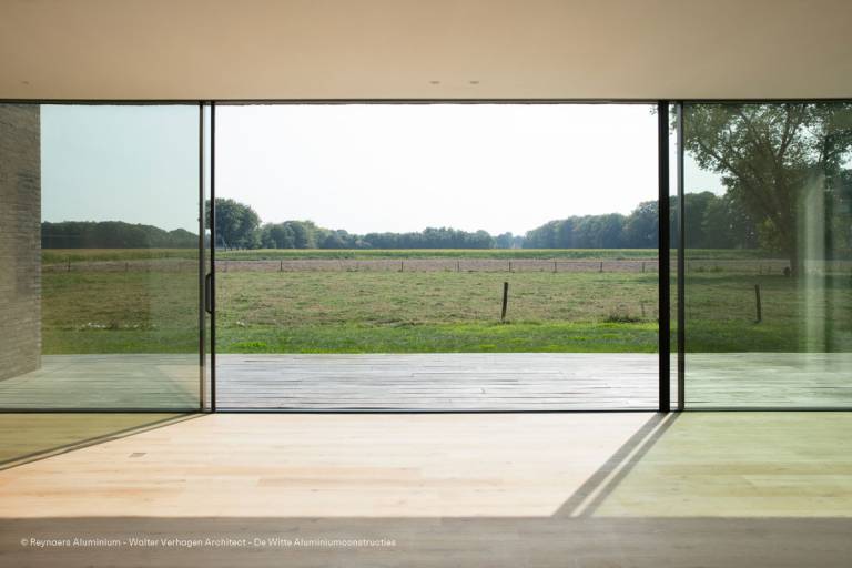 Interior of a private house showcasing a Reynaers HiFinity sliding wall by Walter Verhagen Architect – De Witte Aluminiumconstructies.